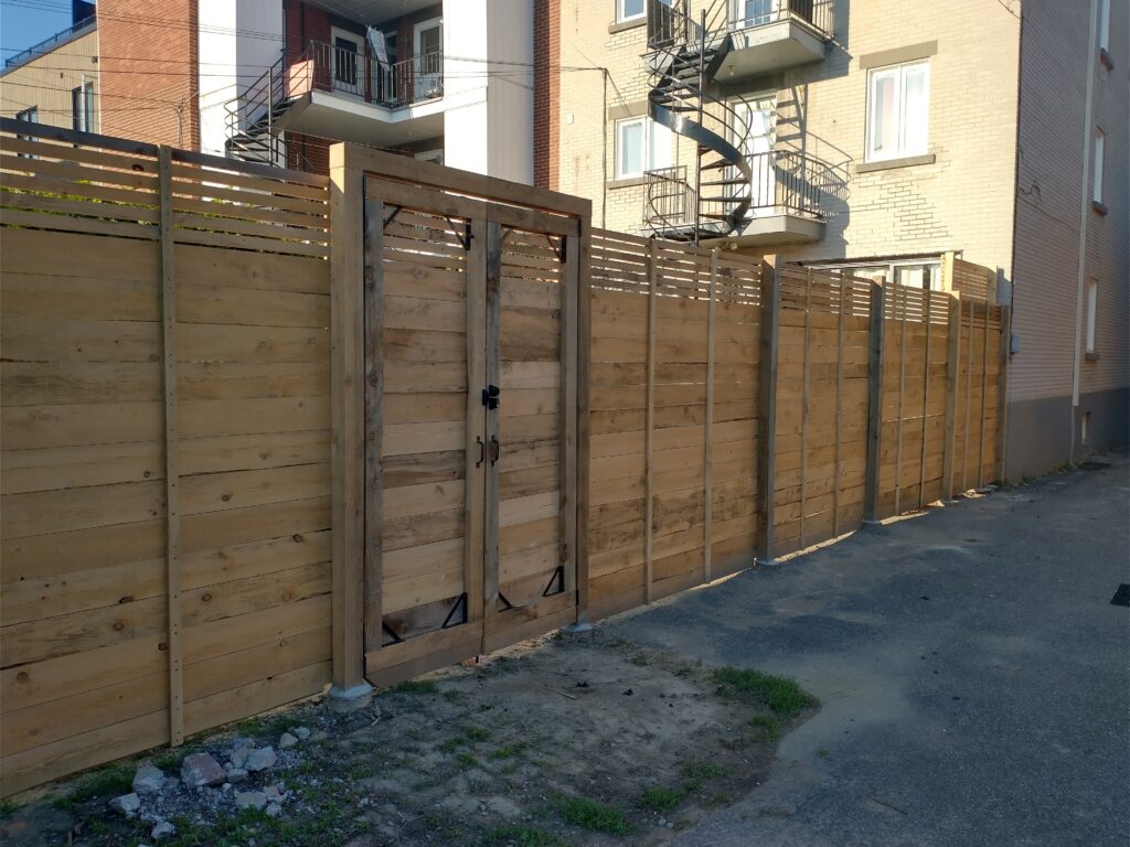 Clôture en pruche avec porte piéton double